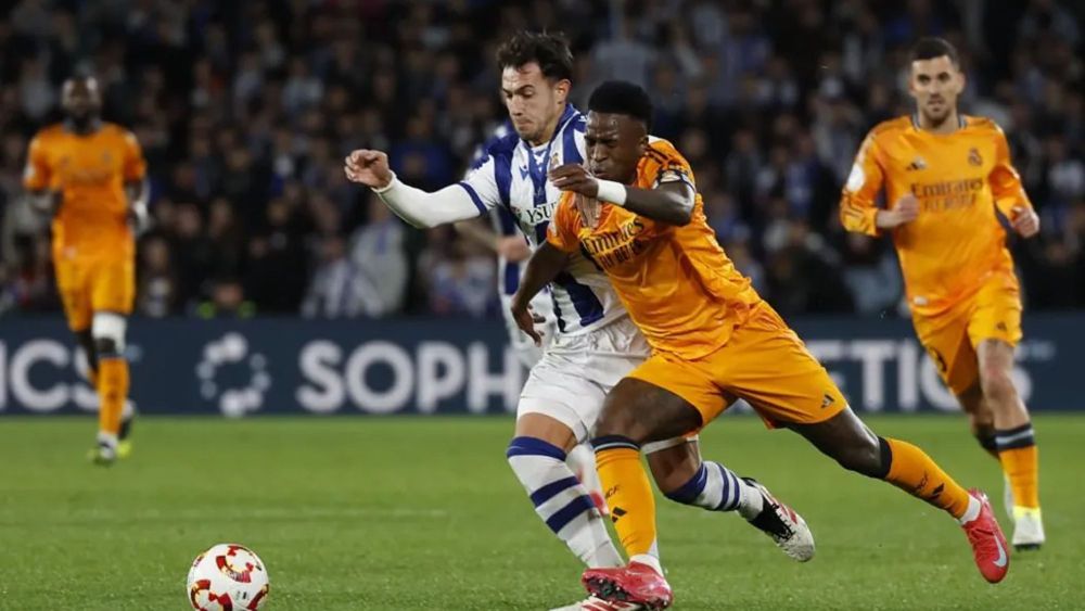 Vinicius Junior, en carrera, intenta escapar de la marca de Martín Zubimendi. Vinicius Junior, en carrera, intenta escapar de la marca de Martín Zubimendi.