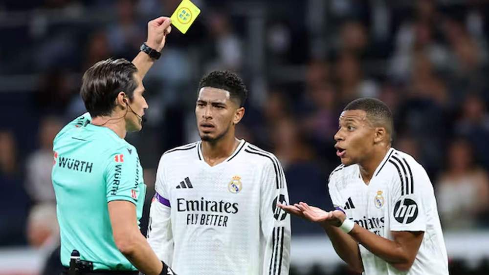 Árbitro mostrando tarjeta amarilla a Mbappé