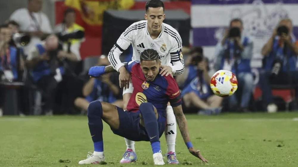 Raphinha, intentando controlar un balón mientras es presionado por Lucas Vázquez. Raphinha, intentando controlar un balón mientras es presionado por Lucas Vázquez.