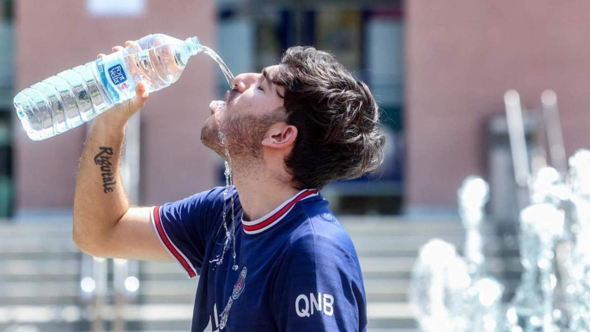 Un joven bebe agua para combatir la segunda ola de calor del verano, a mediados de julio, en Madrid. /