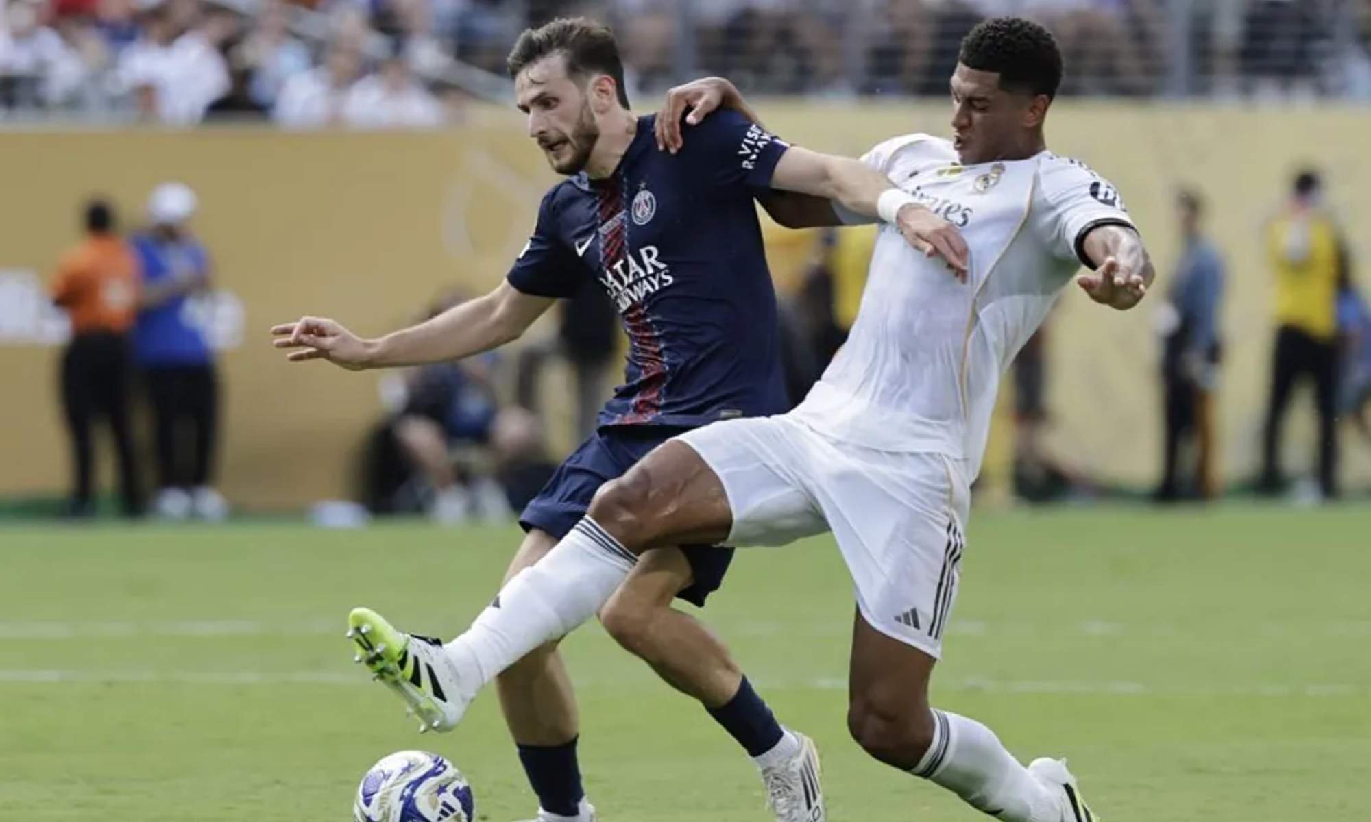 Jude Bellingham, intentando frenar un ataque del PSG conducido por Khvicha Kvaratskhelia.