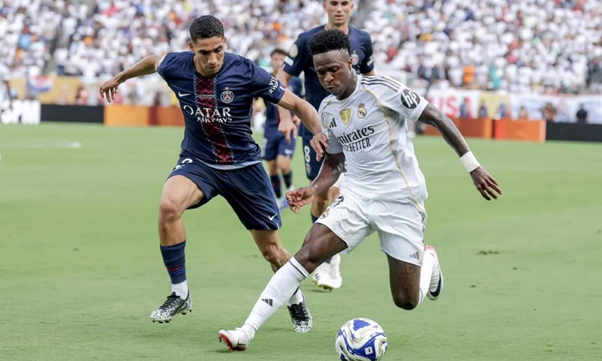 Vinicius, en una jugada protegiéndose, con el balón, de Achraf Hakimi, durante el partido del PSG y el Real Madrid.