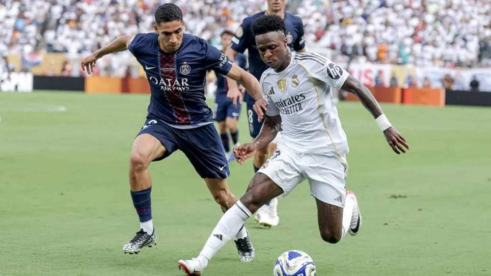 Vinicius, en una jugada protegiéndose, con el balón, de Achraf Hakimi, durante el partido del PSG y el Real Madrid.