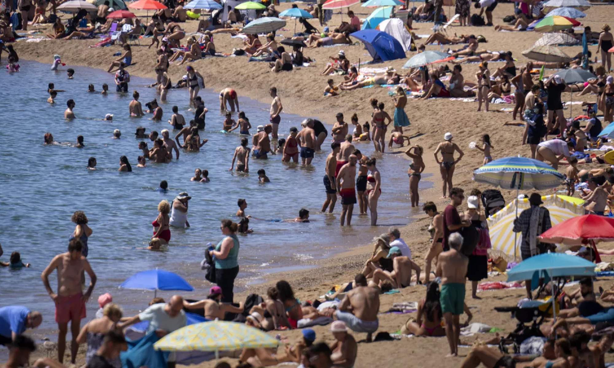 Foto de una playa de España muy calurosa y repleta de gente.