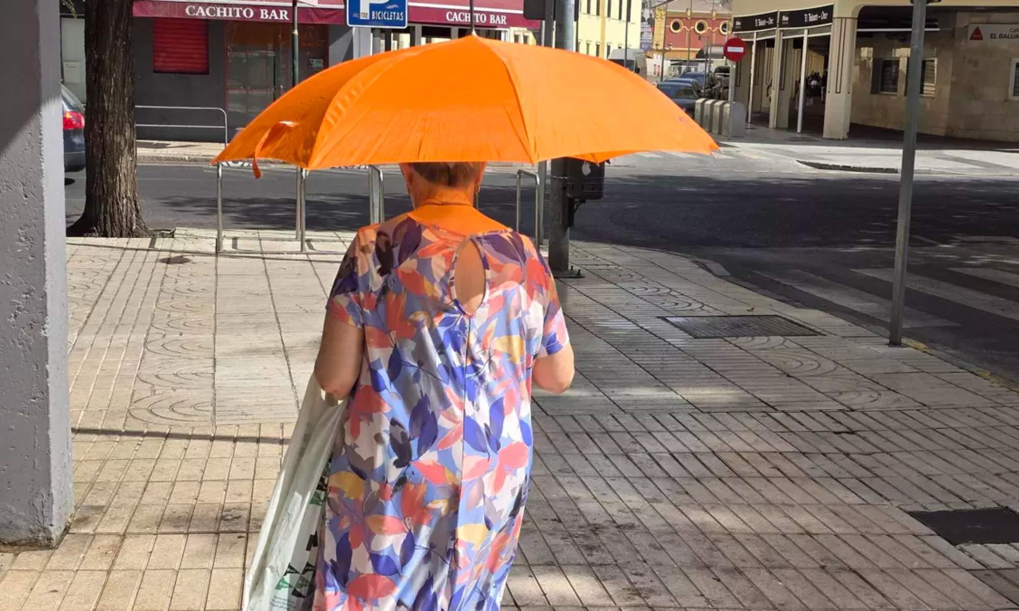 Una mujer se protege, durante este martes, del sol con un paraguas en Badajoz, donde se ha alcanzado la mayor temperatura de toda España en esta segunda ola de calor veraniega.