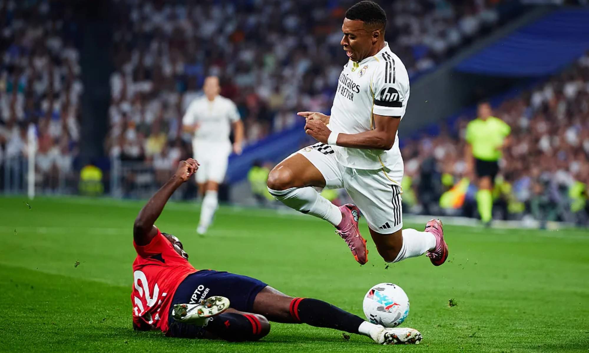 Kylian Mbappe, saltando para evitar la entrada de Enzo Boyomo, durante una acción del encuentro de este martes entre el Real Madrid y Osasuna en el Bernabéu.