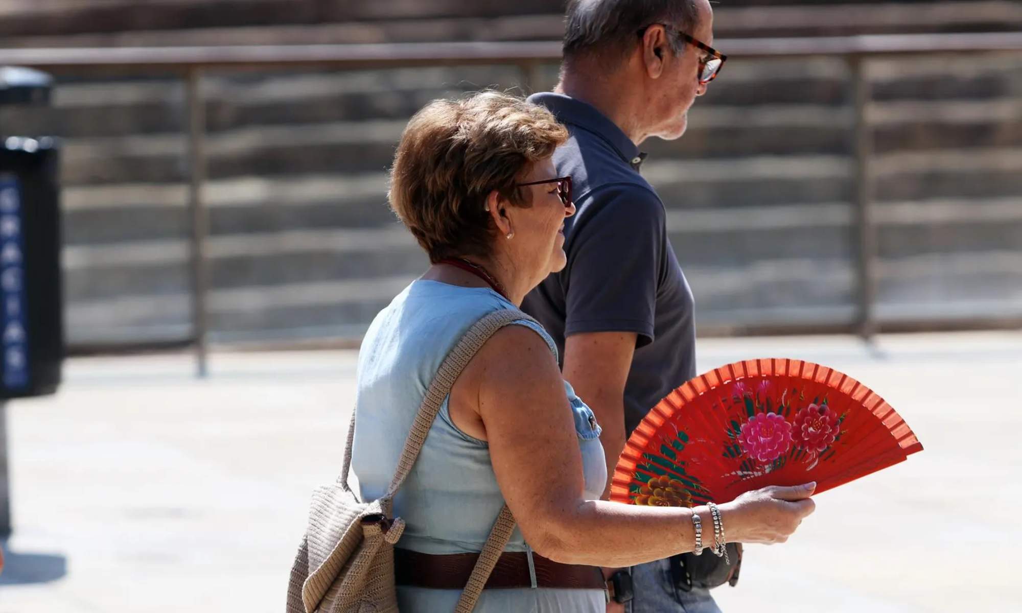 Una mujer, con un abanico, pasea por el pleno centro de Madrid 