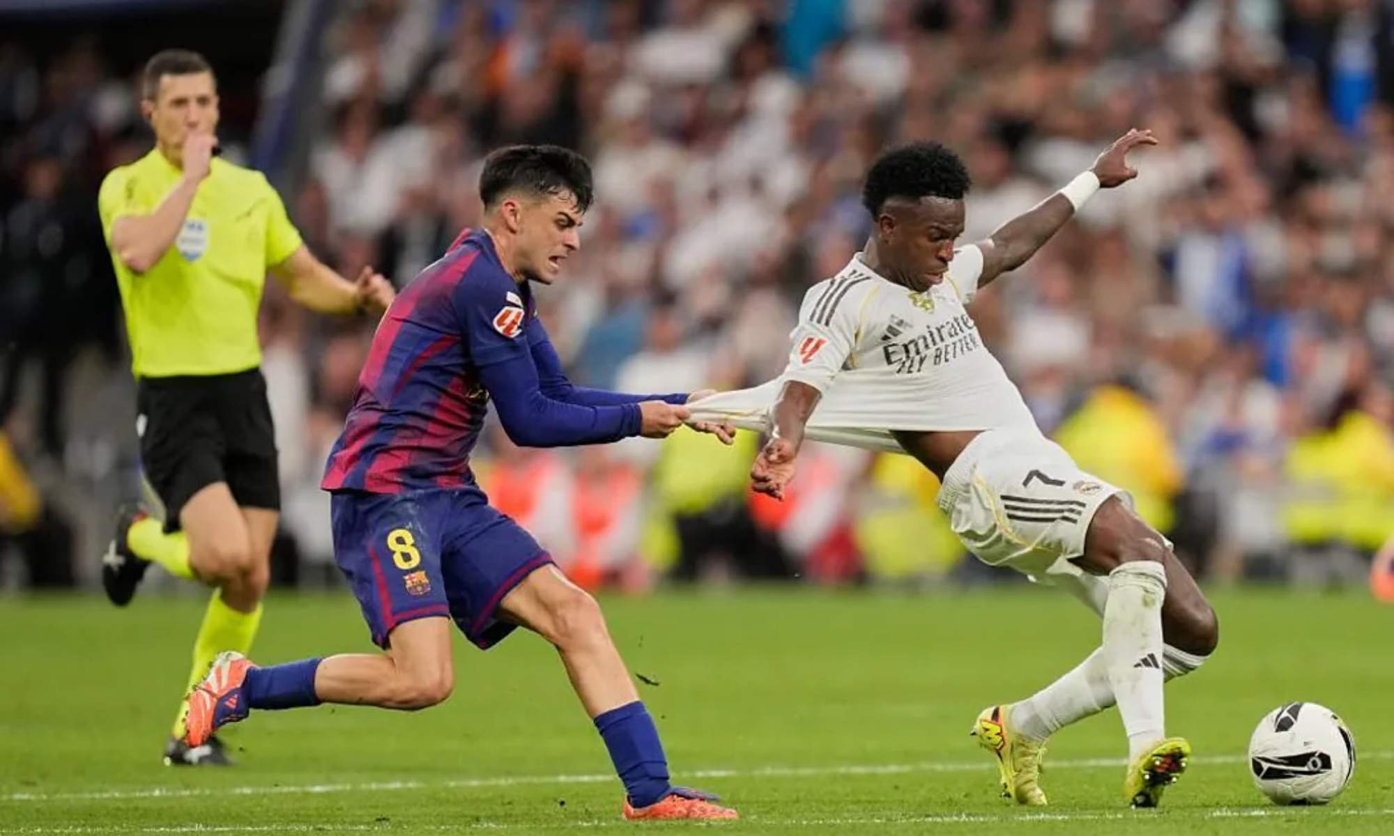 Pedri, agarrando de la camiseta a Vinicius en un contraataque del Real Madrid contra el Barça en el Clásico del domingo pasado. Pedri, agarrando de la camiseta a Vinicius en un contraataque del Real Madrid contra el Barça en el Clásico del domingo pasado.