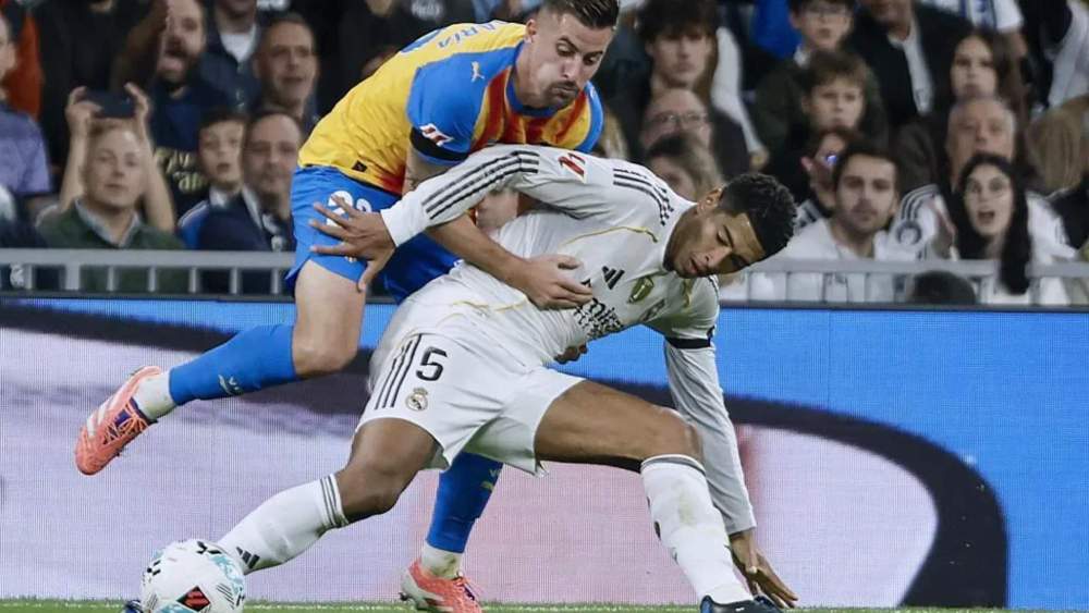 Jude Bellingham protege el balón ante Santamaría. Jude Bellingham protege el balón ante Santamaría.