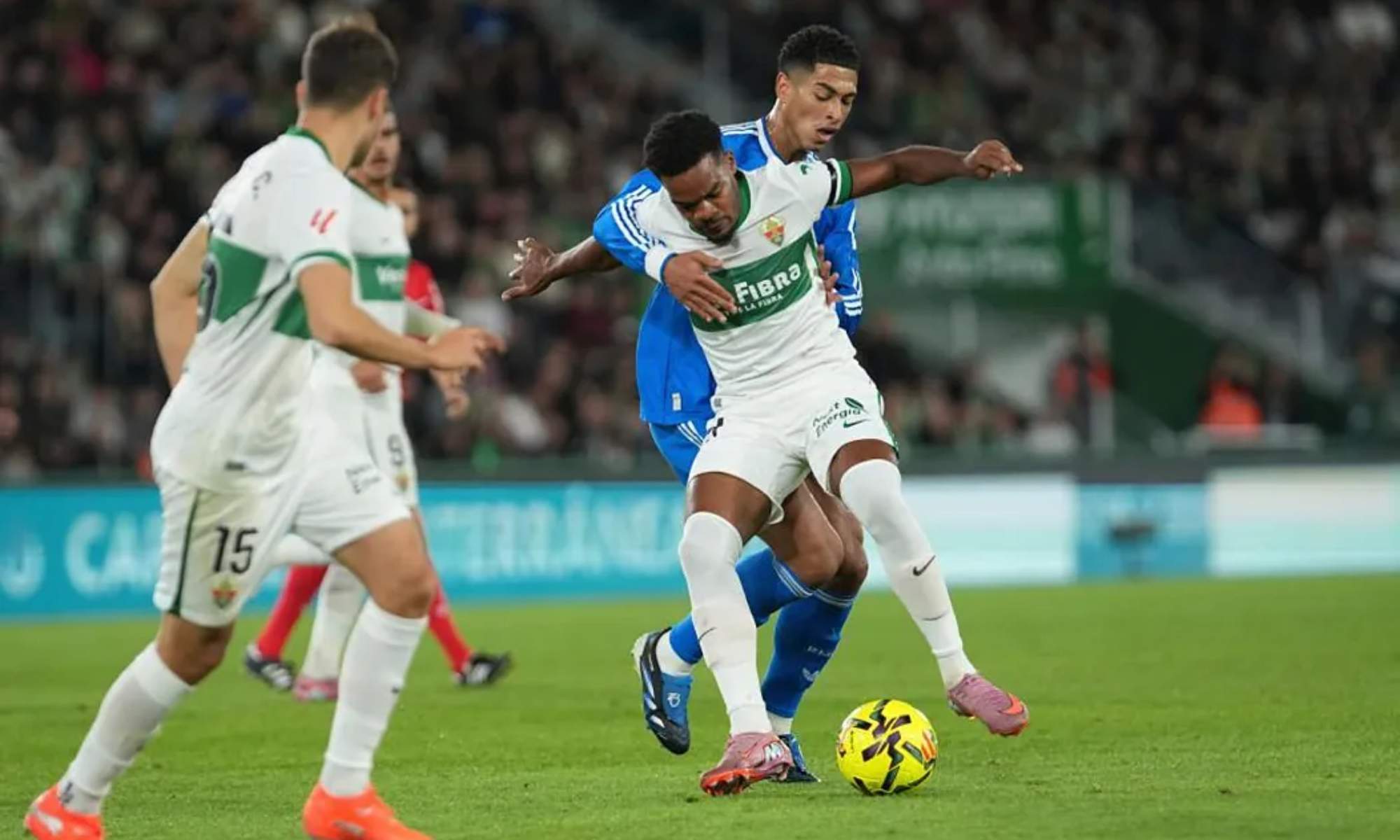 Grady Diangana, protegiendo el balón ante Jude Bellingham, en una acción del partido de esta noche entre el Elche y el Real Madrid.