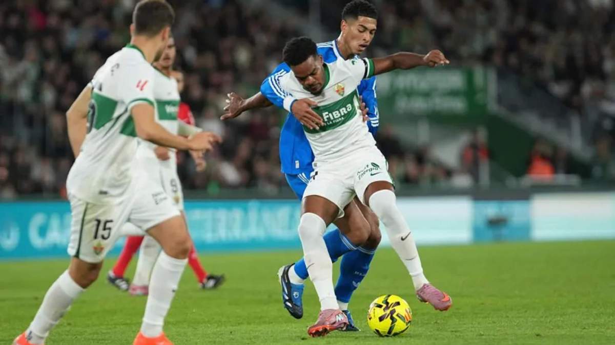 Grady Diangana, protegiendo el balón ante Jude Bellingham, en una acción del partido de esta noche entre el Elche y el Real Madrid.