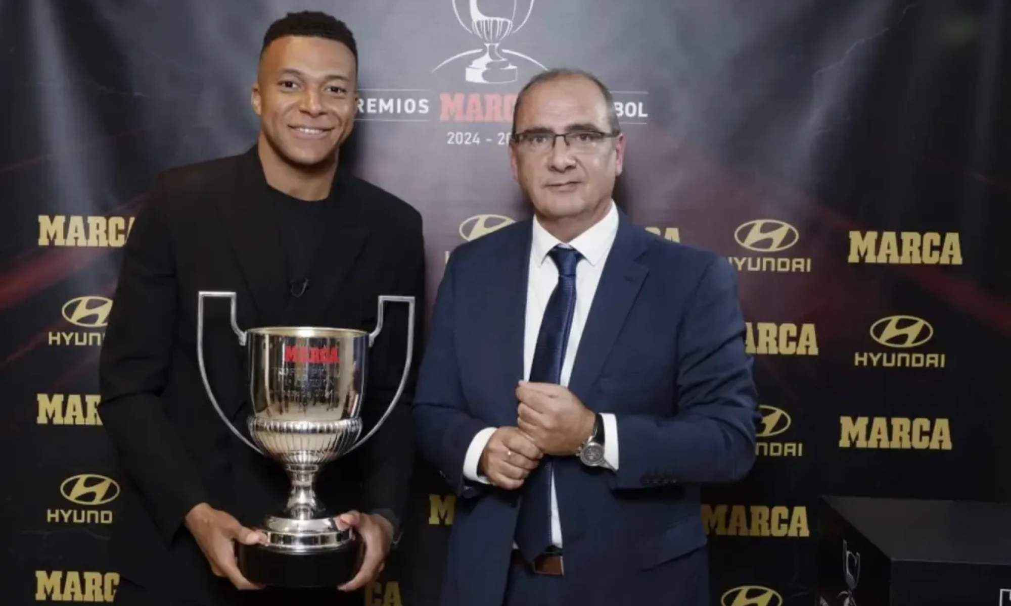 Kylian Mbappé, junto a José Ignacio Gallardo, director de 'Marca', posa con el Trofeo Pichichi.