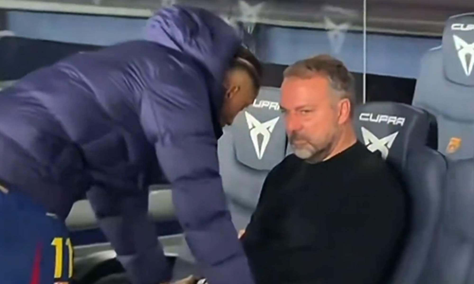 Hansi Flick hundido y Raphinha hablando con él.