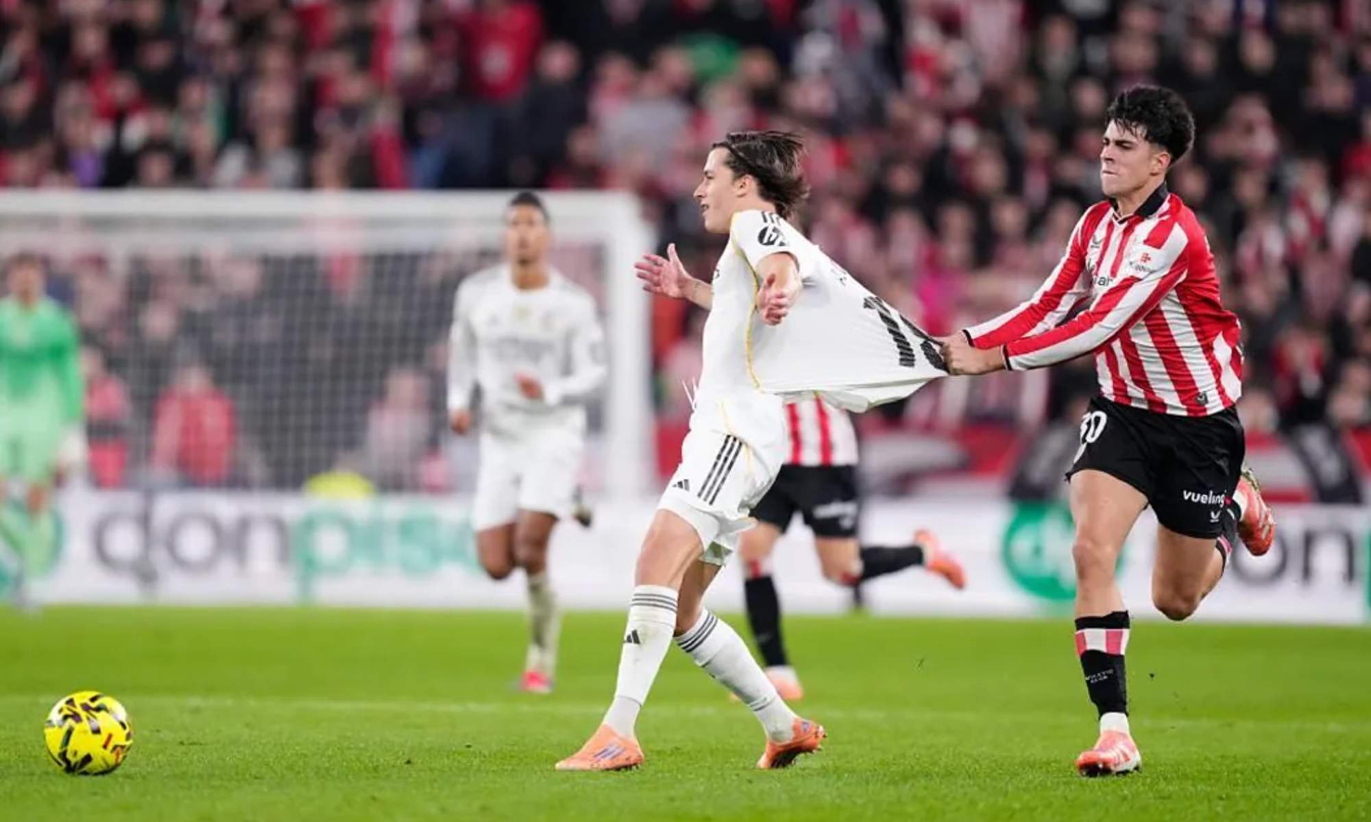 Alejandro Rego agarra de la camiseta a Álvaro Carreras para evitar que se escape, en la segunda parte del encuentro entre el Athletic Club y el Real Madrid.