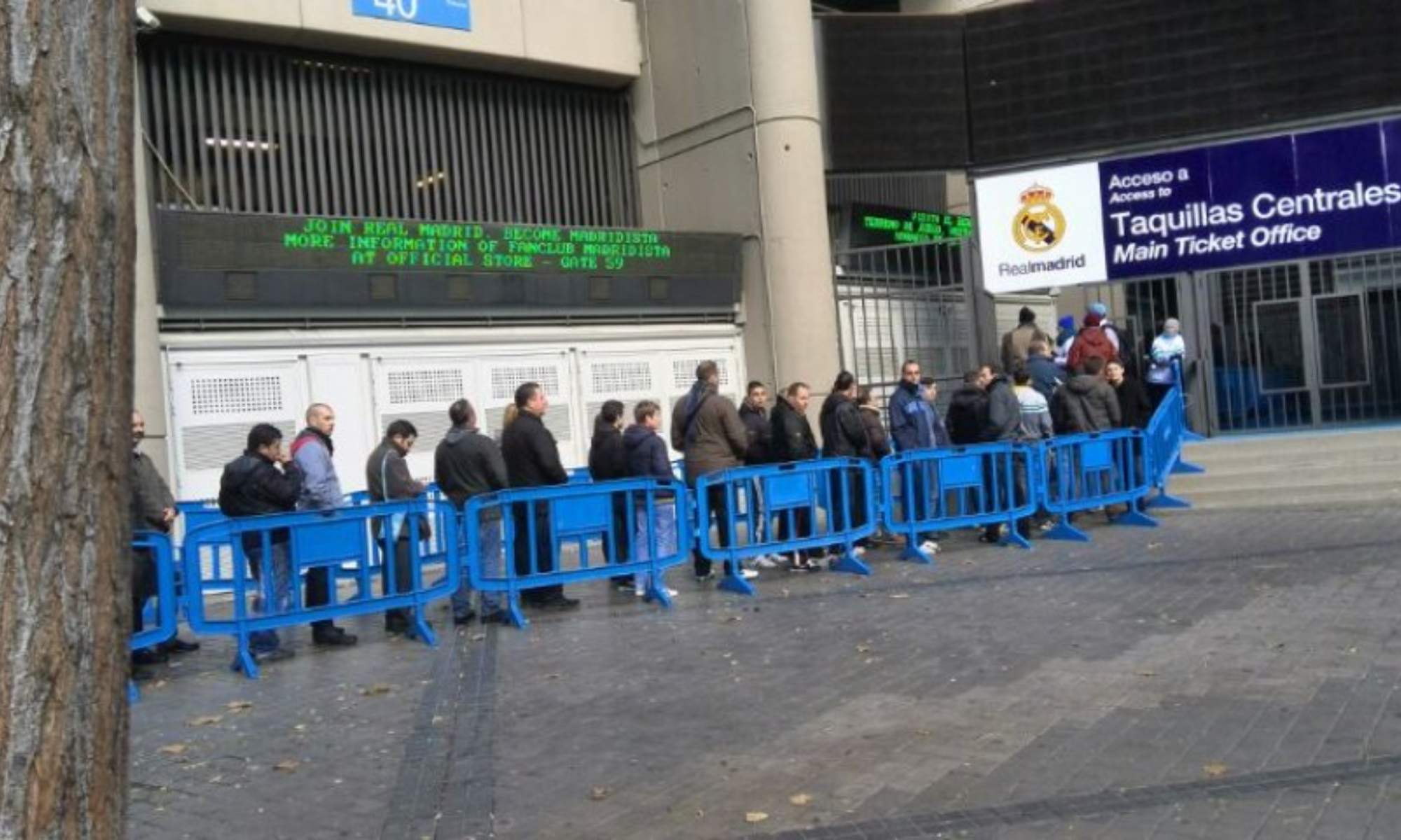 Varias personas, haciendo cola para comprar entradas en el Santiago Bernabéu.