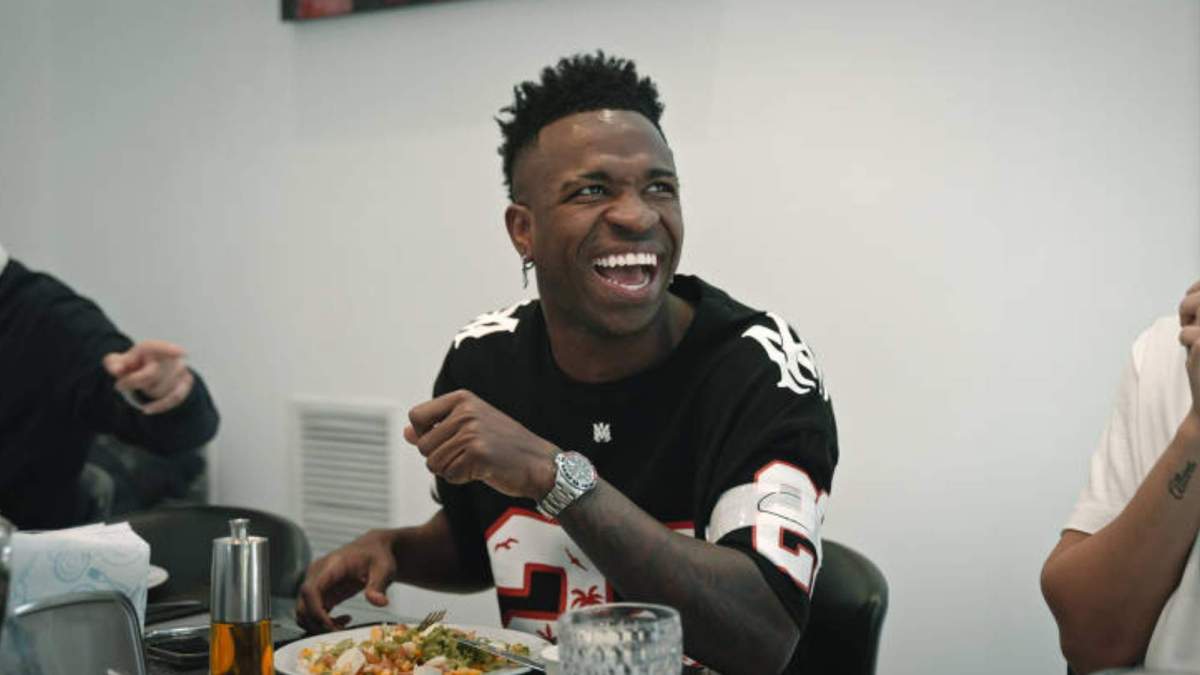 Vinicius Junior sonriendo mientras come