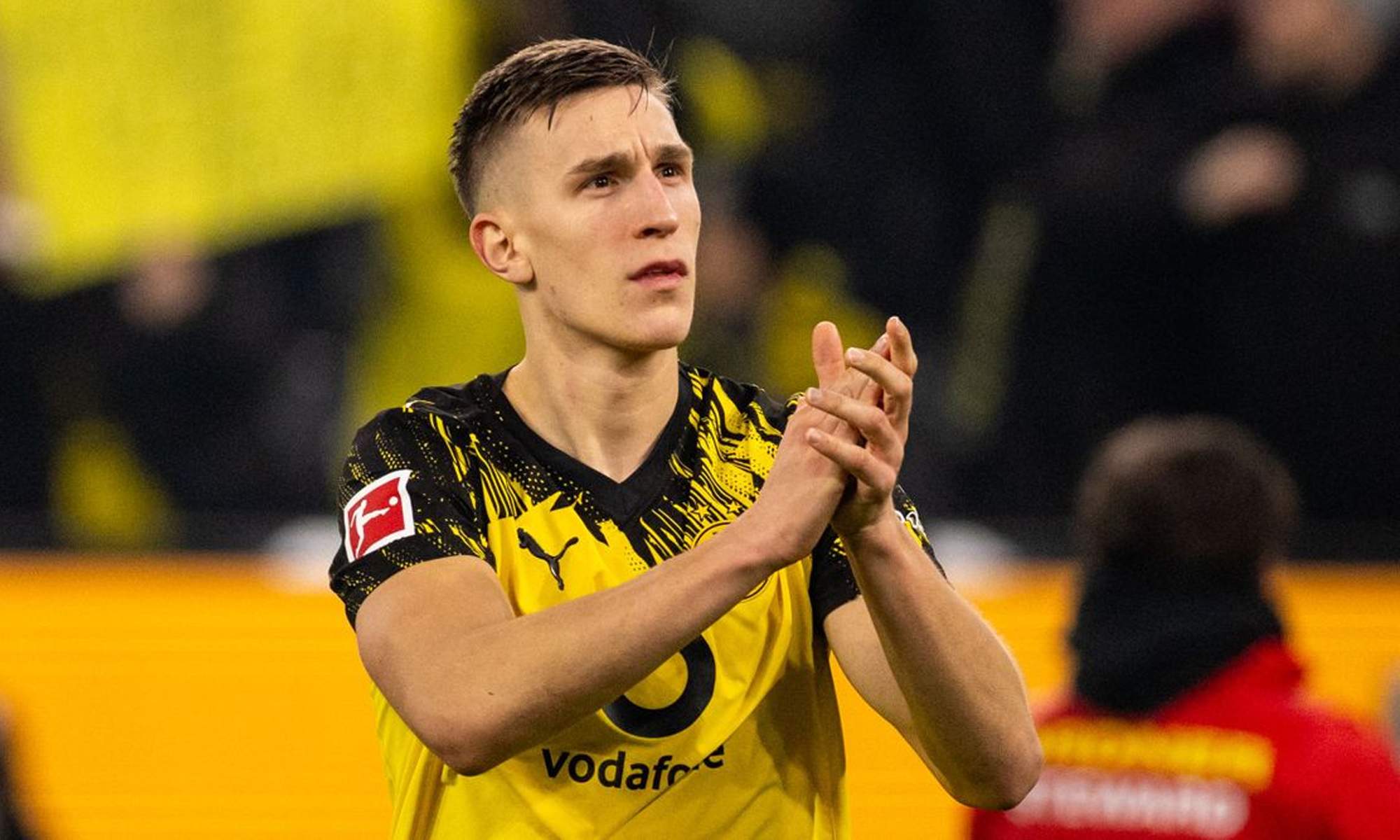 Nico Schlotterbeck aplaudiendo en un partido con el Borussia Dortmund. 