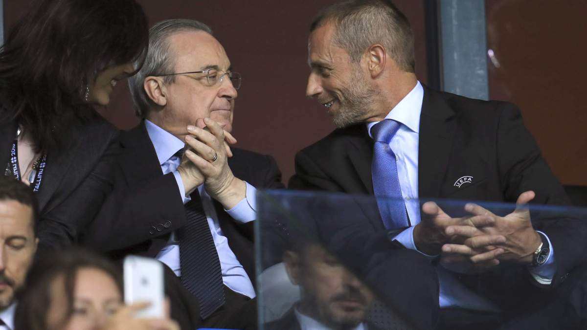 Florentino Pérez y Ceferin hablando durante un partido.