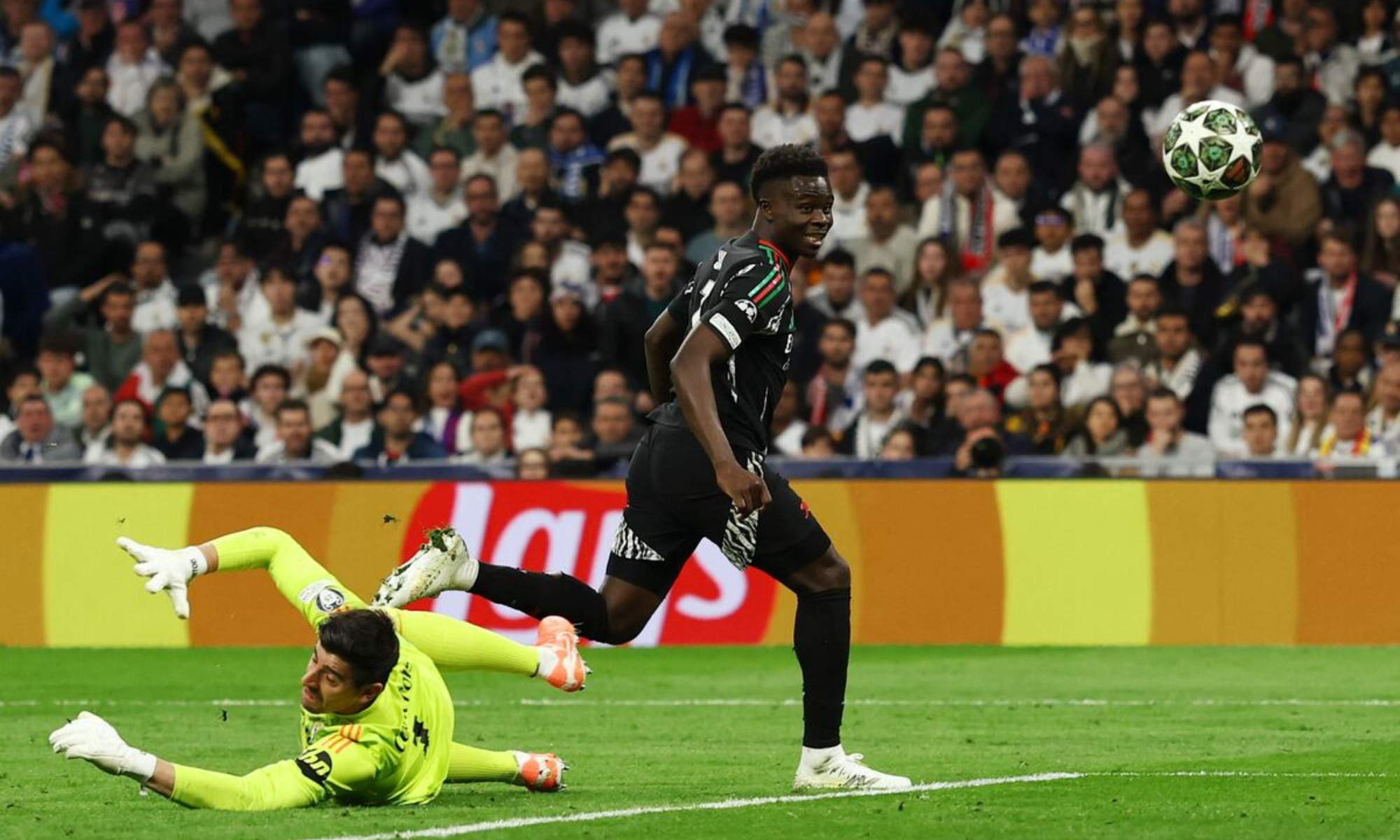 Buyako Saka, batiendo a Thibaut Courtois durante el partid del año pasado en el Santiago Bernabéu entre el Real Madrid y el Arsenal.