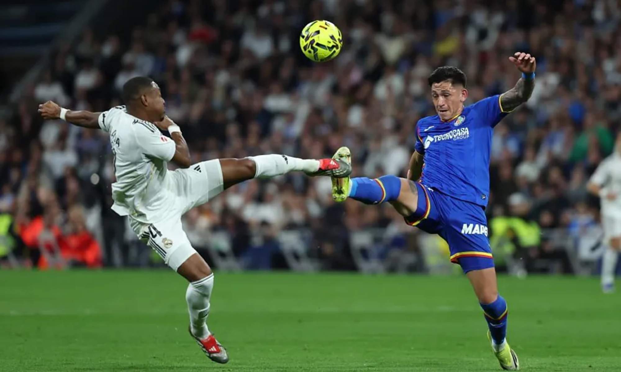 David Alaba y Luis Vázquez, chocando las botas al intentar dar al balón durante la primera parte del partido del Real Madrid y el Getafe.