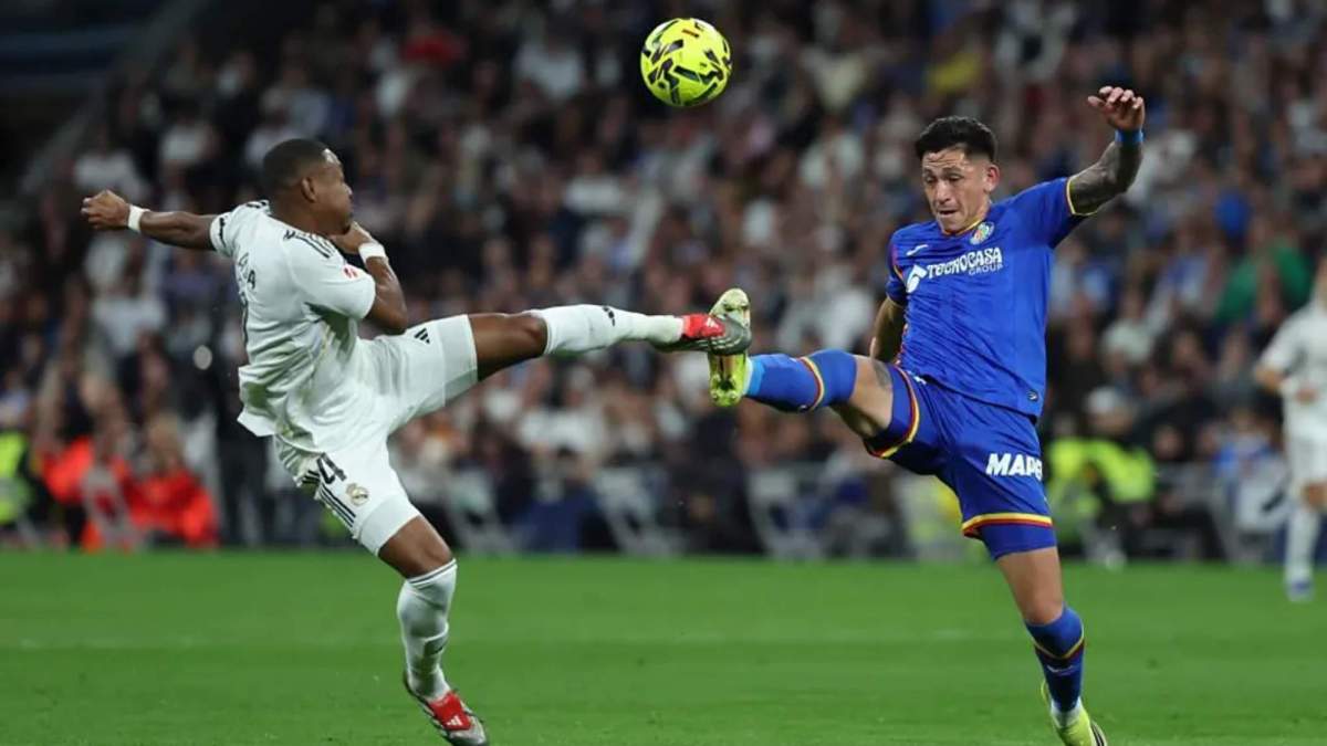 David Alaba y Luis Vázquez, chocando las botas al intentar dar al balón durante la primera parte del partido del Real Madrid y el Getafe. David Alaba y Luis Vázquez, chocando las botas al intentar dar al balón durante la primera parte del partido del Real Madrid y el Getafe.