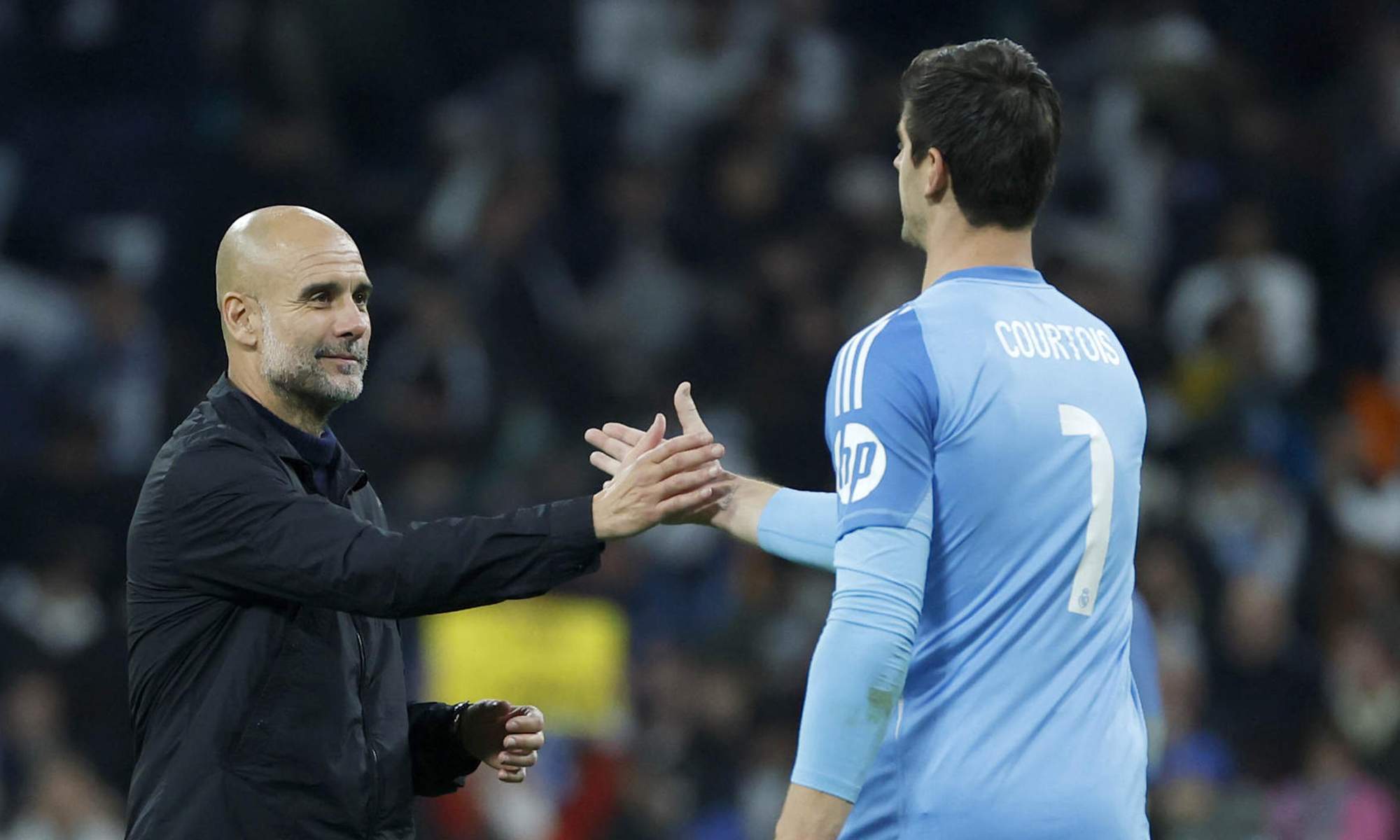 Pep Guardiola y Thibaut Courtois saludándose en un partido entre el Real Madrid y el Manchester City. 