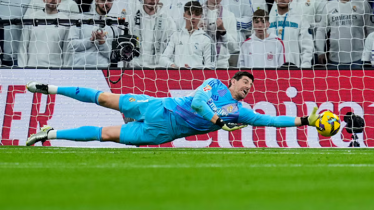 Thibaut Courtois haciendo una gran parada con el Real Madrid. 