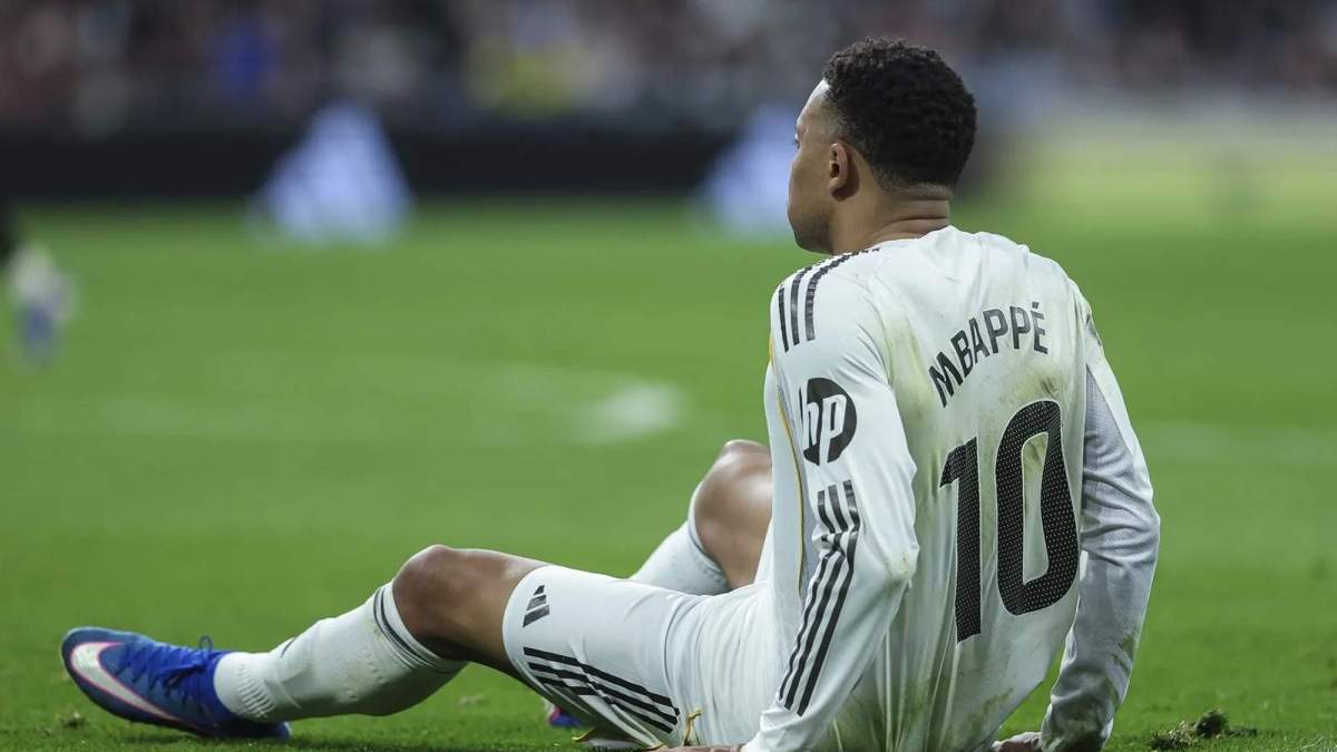 Kylian Mbappé sentado en el suelo en un partido.