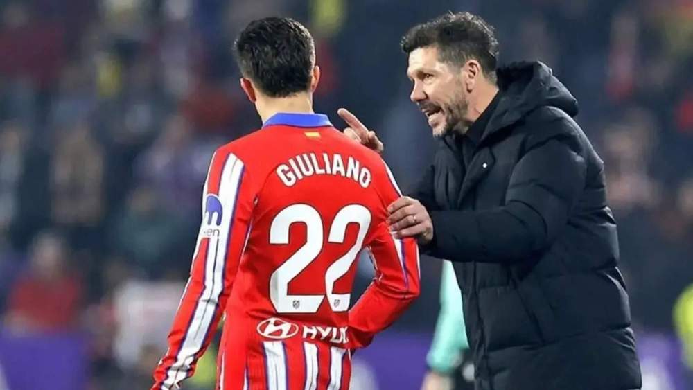 Diego Pablo Simeone, hablando con su hijo Giuliano, el pequeño de los tres que tiene, durante un partido del Atlético.