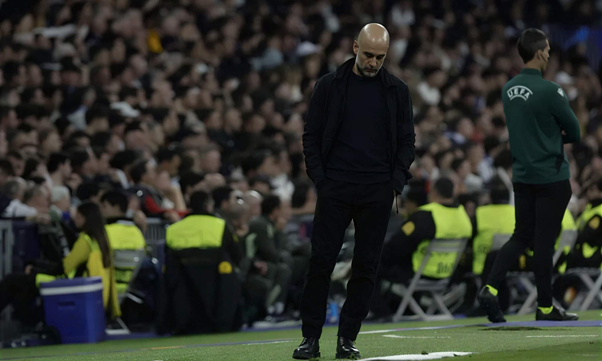 Pep Guardiola, con rostro serio y cabizbajo, durante el partido de esta noche entre el Real Madrid y el Manchester City en el Santiago Bernabéu.