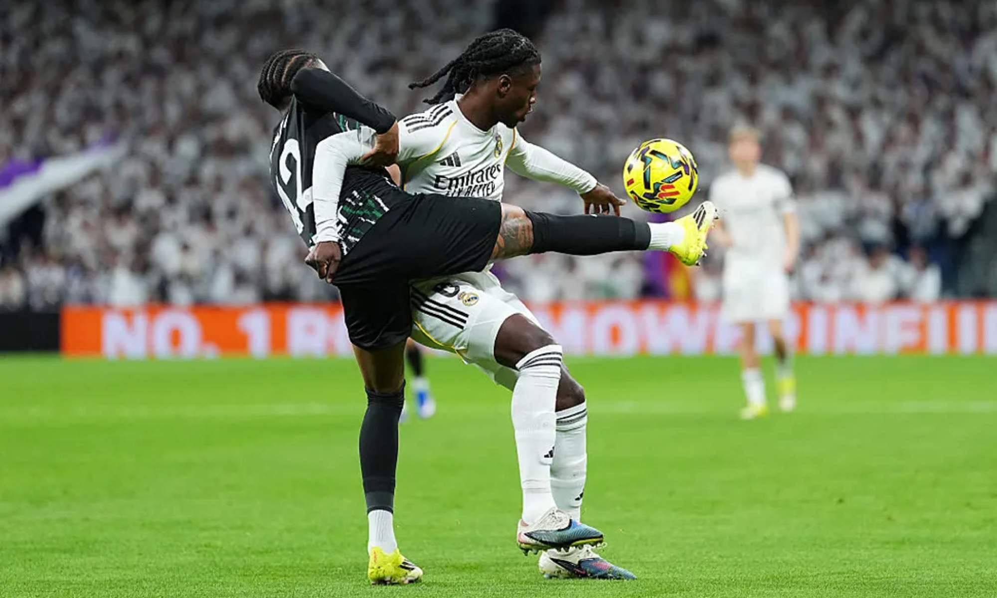 Camavinga, protegiéndose ante la pierna de Buba Sangaré para quitarle la pelota durante un momento del partido entre el Real Madrid y el Elche.