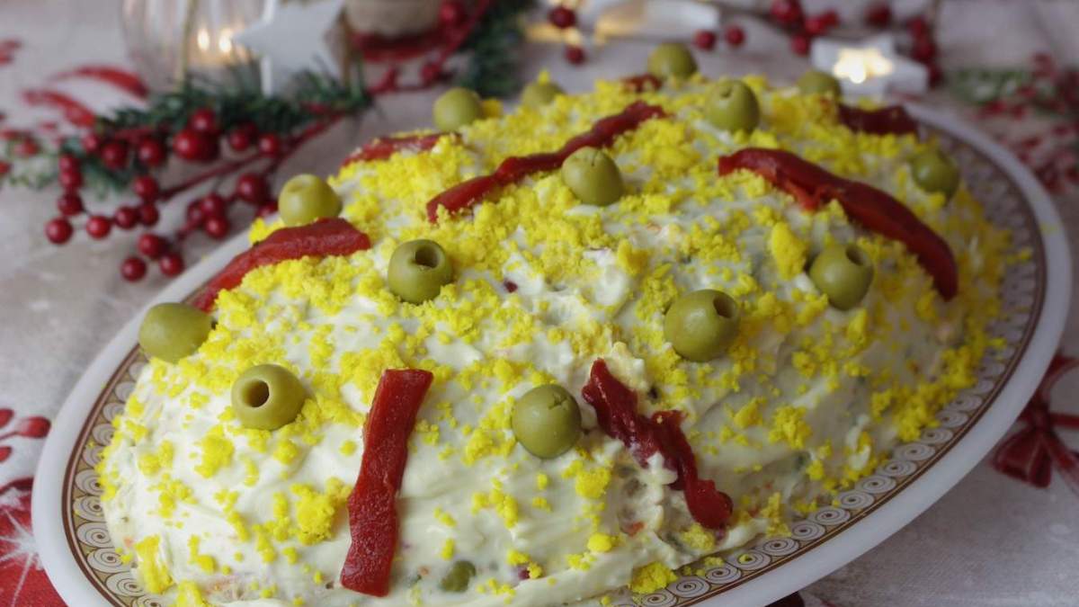 Ensaladilla rusa servida y decorada en una pequeña fuente. 