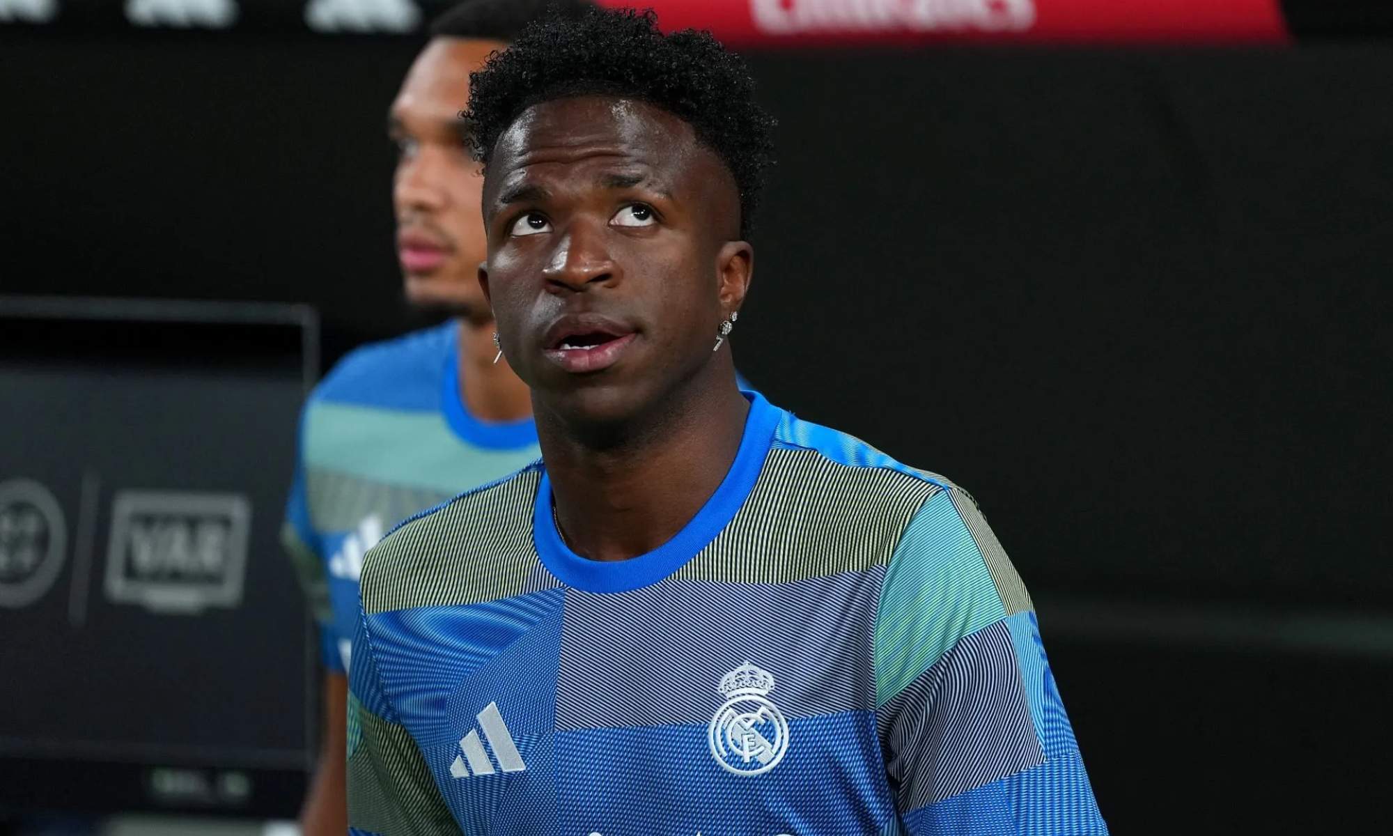 Vinicius Junior, con rostro serio, en el banquillo del Santiago Bernabéu durante un partido de esta temporada con el Real Madrid.
