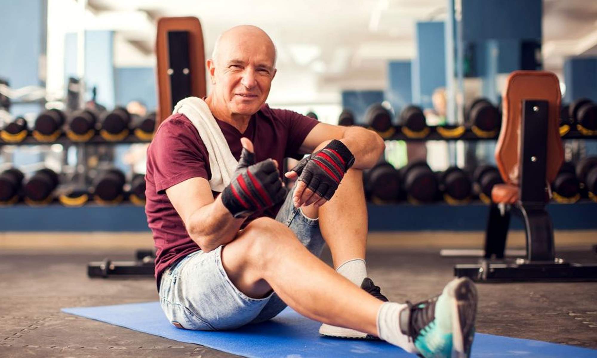 Una persona mayor haciendo deporte en el gimnasio. 