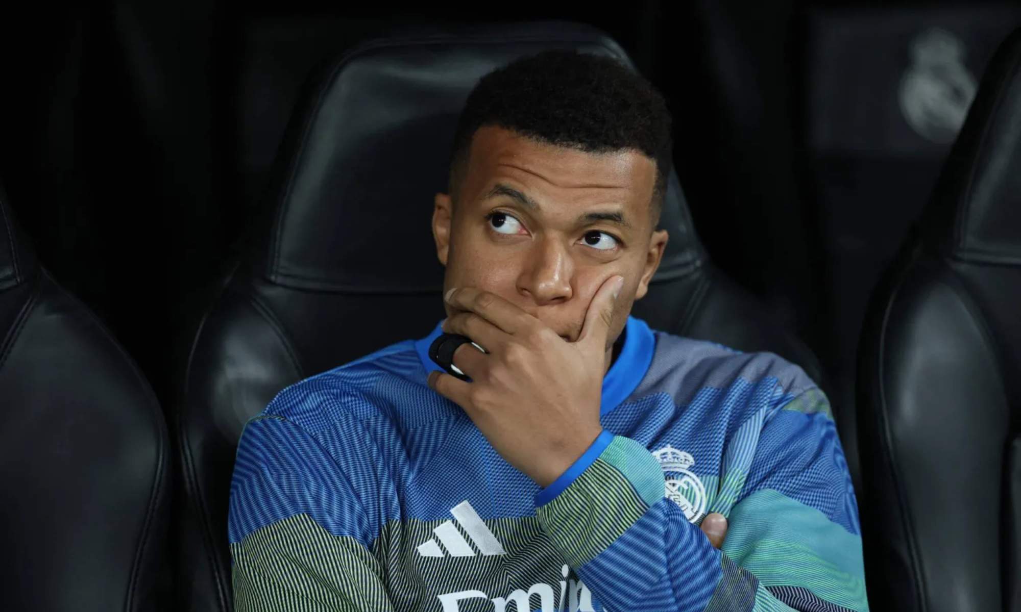 Kylian Mbappé, con rostro serio, en el banquillo del Santiago Bernabéu en un partido del Real Madrid durante esta temporada.