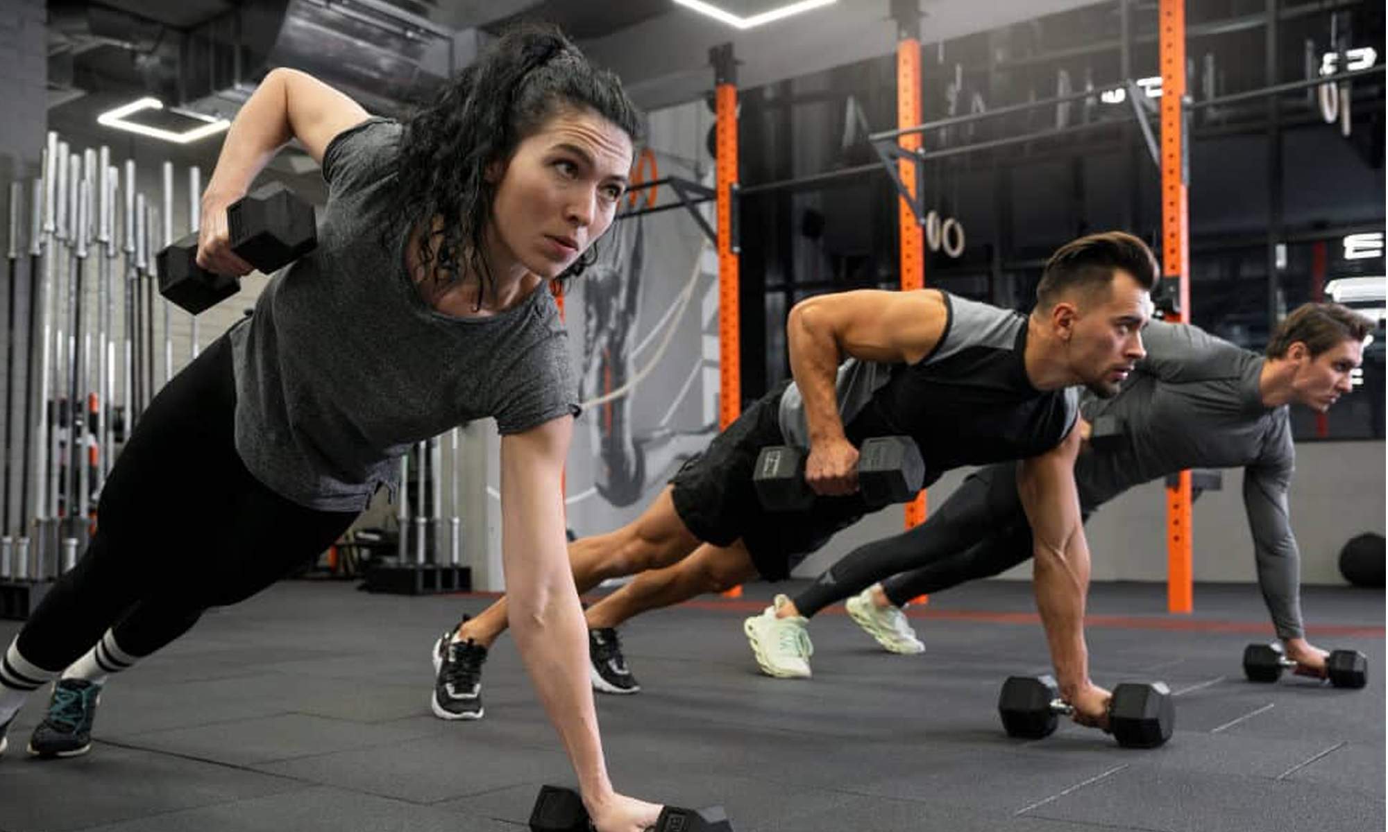 Personas entrenando fuerza en el gimnasio.