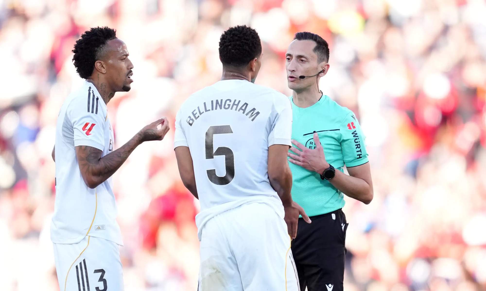 El colegiado José María Sánchez Martínez, hablando con Éder Militao y Jude Bellingham en un partido del Real Madrid durante esta temporada.