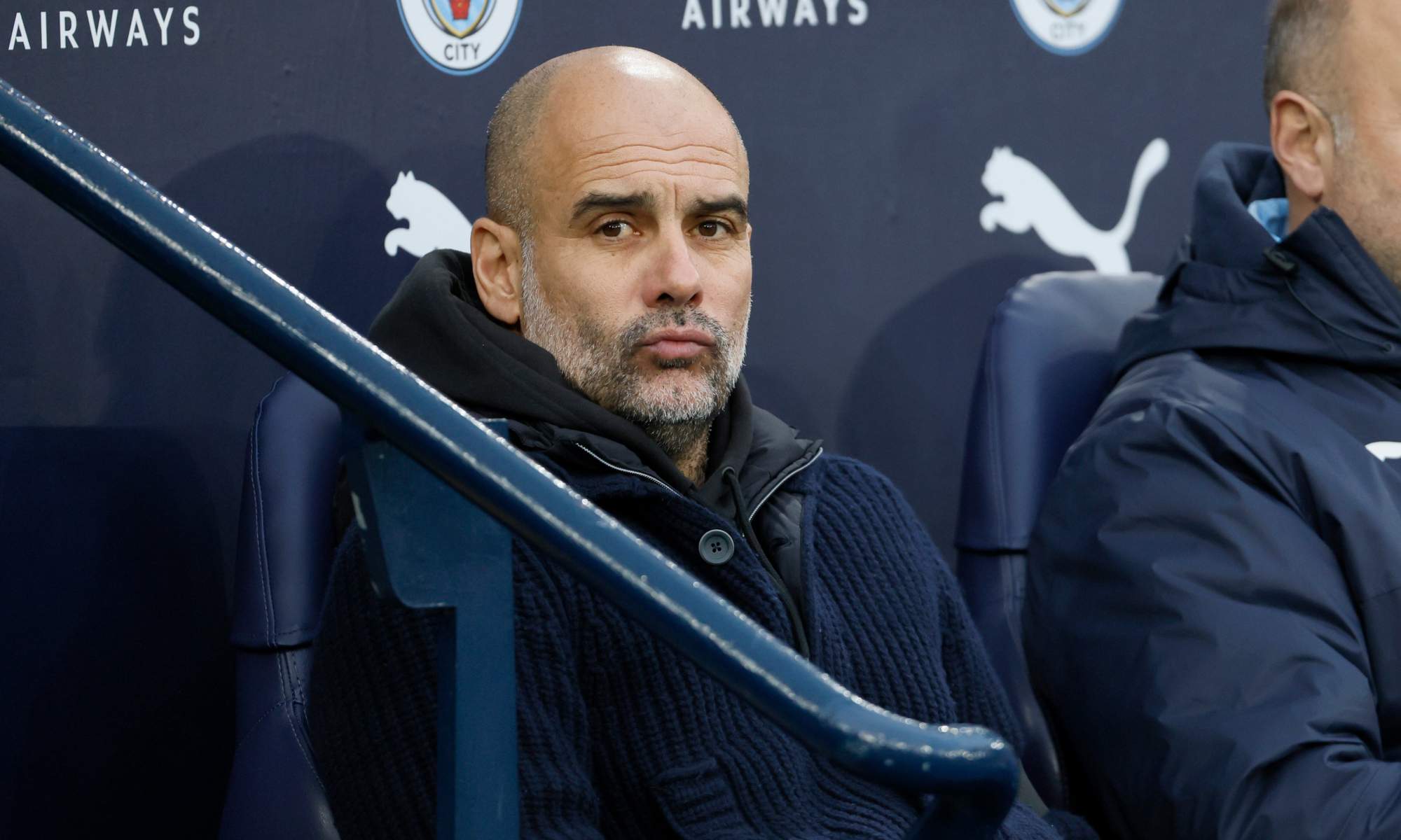 Pep Guardiola, sentado en el banquillo del Etihad durante un partido del Manchester City.