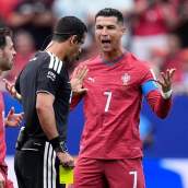 Cristiano Ronaldo protesta una acción al colegiado del partido, Abdulrahman Al-Jassim, en presencia de Bernardo Silva.